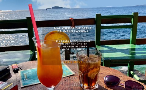 Die Seele baumeln lassen? - Das Bild zeigt einen Tisch mit Blick auf's Meer. auf dem Tisch stehen 2 bunte Longdrinks. Die Aufschrift des Bildes ist: "Die Seele ernährt sich von den schönsten Momenten im Leben" (Maori Weisheit)